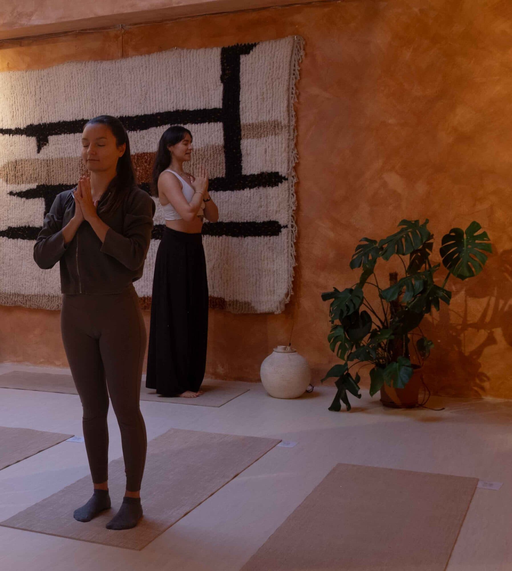 Two practitioners in prayer pose during a yoga class in Lisbon